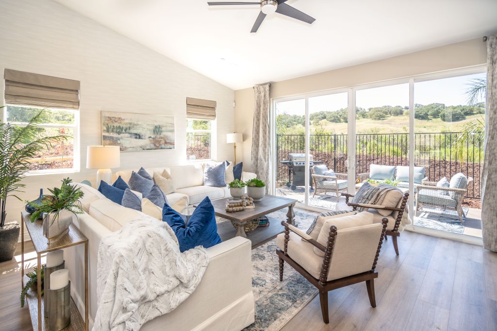 A living room with a fireplace and sliding glass doors in meadow view townhomes at rice ranch.